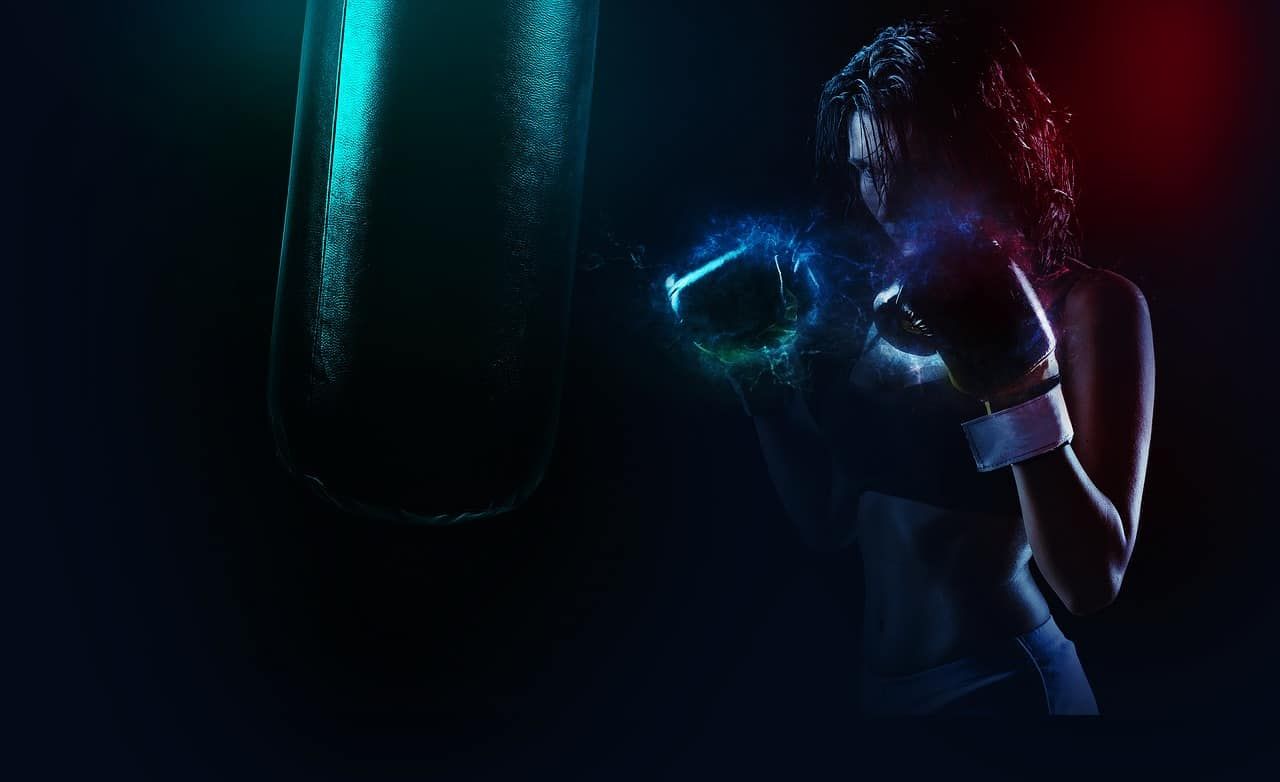 Frau beim Boxing-Workout. Die Farben zeigen die Anspannung, die Fäuste sind von einer Art blauer Aura umgeben. Wenn Du alles aus deinem Workout rausholen willst, dann brauchst Du Durchhaltevermögen, was man bei der Frau am Gesichtsausdruck erkennen kann.