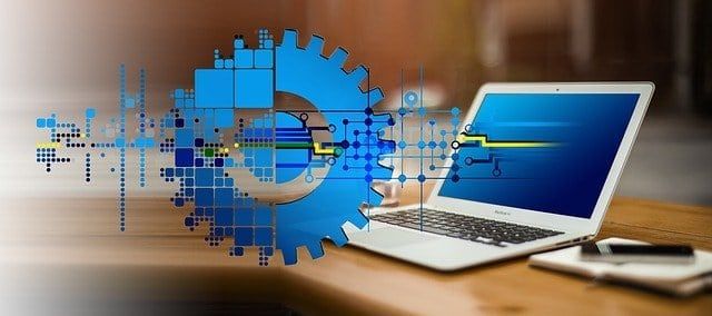 Die Digitale Transformation schematisch in Form von Zahlrädern und Schaltkreisen und einem Notebook dargestellt.