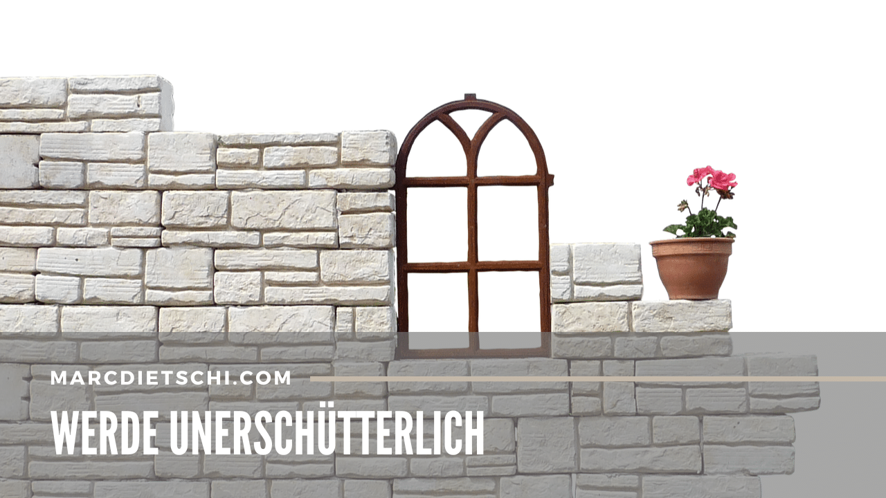Banner mit 'WERDE UNERSCHÜTTERLICH' für marcdietschi.com, weiße Mauer mit Rundbogenfenster, rosa Geranie auf Mauervorsprung.
