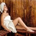 Das Bild zeigt eine Person, die sich in einer Sauna oder in einem Wellnessbereich entspannt.