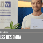 Marc Dietschi mit dem EMBA-Diplom vor dem PHW-Logo